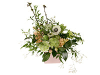 A lovely and casual spring floral design in muted colors combines anemones, ranunculus, tulips, hyacinths, vines, camellia leaves, and blooming branches. 