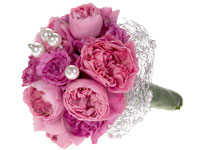 A gorgeous wedding bouquet features pink garden roses and is finished with lovely pearl pins.