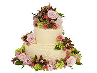 It’s easy to decorate a wedding cake with fresh flowers and foliage like coral spray roses, cranberry cymbidium orchids, blush roses, lime green hydrangeas, and galax leaves.