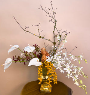 A lovely gold compote full of anthurium, burning bush, date palms, spectabilis, dendrobium orchids, and a Japanese maple branch.