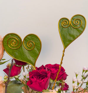 Aluminum wire that has been manipulated into a heart shape and backed with a galax leaf.