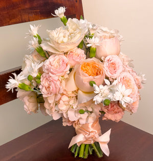 An elegant wedding bouquet made with Eugenie and Juliet garden roses, Wedding Rose Ever spray roses, tinted hydrangea, blush carnations, and star dianthus.