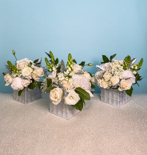A trio arrangement in square sparkling silver vases, full of white roses, paper whites, peonies, ornithogalum, Italian ruscus and salal. 