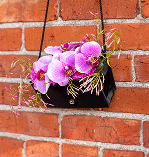 A foam-free floral design makes a statement by mixing orchids and jasmine vine in a stylish purse.