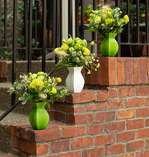 A trio of vases in a clean white and green color palette combines Princess Midori roses, lisianthus, astrantia, grasses, mint, and eryngium.