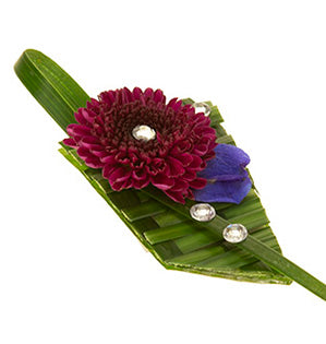 A beautiful modern prom wearable corsage is made of woven lily grass and finished with a button pom and rhinestones. 