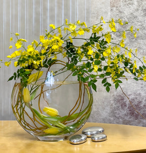 This contemporary yellow design featuring oncidium orchids, willow, and tulips.