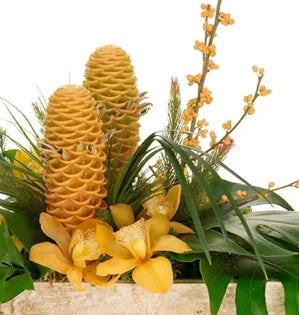 Decorative arrangement with yellow flowers and green leaves on a white background