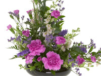 A classic asymmetrical floral design mixes pink carnations, blush larkspur, purple statice, hot pink mini carnations, and Israeli ruscus for a lovely effect.