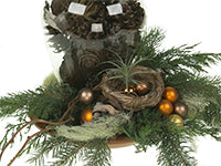 One trend for the Christmas season includes woodlands natural like that of this floral design which mixes evergreens, tillandsia, pine cones, a succulent wreath, kiwi vine, and a bird’s nest with holiday ornaments.