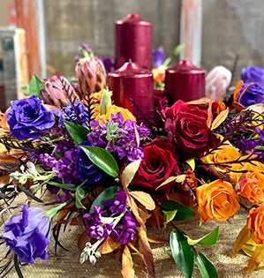 An arrangement in a unique analogous color scheme features grevillea, leucadendron, lisianthus, stock, and spray roses.