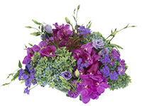 A gorgeous, full arrangement of green and soft blue hydrangea, vibrant purple orchids, purple adjuratum, moon shade mini carnations, lysianthus, and bursts of tilancia.