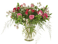 A dramatic vase of three kinds of roses in colors of red, fuchsia, and pink and white bi-color decorated with dainty wax flowers and foliage of honey bracelet, ruscus, and plumosa.