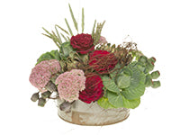 A dramatic and eclectic centerpiece of striking red roses with artichokes, kale, wheat, sedum, eucalyptus pods and banyan vine.