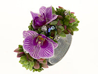 A wrist corsage featuring succulents, orchids, and gems.