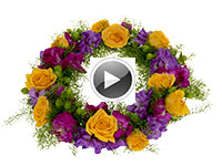 A gorgeous, colorful flower crown of deflexus, hot pink and purple stock, vibrant yellow roses, and hypericum berries.