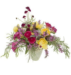 A sweeping arrangement of vibrant summertime flowers like nadia, freesia, ranunculus, Salvia, and Toulouse Lautrec garden roses complimented by blue green foliages like lamb's ear and eucalyptus.