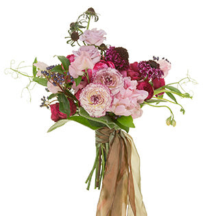 A bespoke style bouquet combines the soft lavender Eloquence roses, Garnet Gem spray roses, Blueberry roses, Yves Piaget garden rose, peonies, sweet pea, scabiosa, viburnum, and the impressive Elegance Bianco Striato ranunculus.