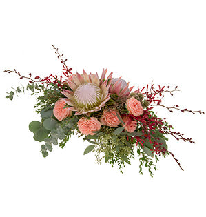 King Protea blooms, garden roses named Natural Pink, James Storie orchids, seeded eucalyptus, scabiosa pods, silver dollar eucalyptus, and Gunni eucalyptus come together in horizontal line design to make this bold bridal bouquet.