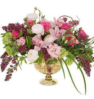 A compote design features viburnum, ranunculus, lisianthus, garden roses, cymbidium orchids, and lilac in purple, dark pink and light pink colors.