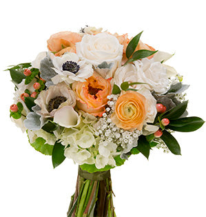 A lovely hand tied wedding bouquet mixes peach roses, white anemones, ivory callas, silver dusty miller, coral hypericum berries, baby's breath, and Israeli ruscus.