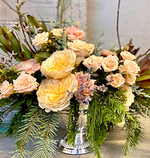 A compote centerpiece in muted colors features two kinds of garden roses: Effie and Sahara Sensation mixed with carnations, leucadendron, and limonium for a beautiful antique look.