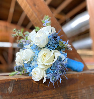 A small elopement wedding bouquet mixes White Cloud garden roses, blue hydrangea, tweedia, and eryngium for a beautiful effect.