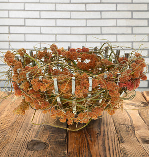 Twisting willow and draping amaranthus come together to form a sculptural nest