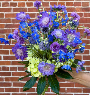 A stunning hand-tied bouquet featuring an analogous color harmony of violet, blue, and green.
