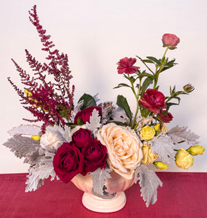 A bespoke inspired classic crescent design using, dusty miller, butterfly ranunculus, lisianthus, astilbe, spray roses, and garden roses.