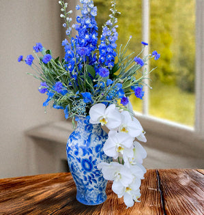 Ming vase featuring phalaenopsis orchids, hydrangea, Bella Donna delphinium, and Bachelor buttons.