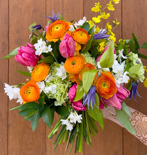 This design brings together tulips, ranunculus, fragrant paperwhites, and clematis.