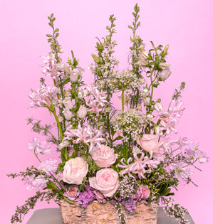 A horizontal arrangement with a natural style to the design full of Kiera garden roses, Loli spray roses, nerine lilies, larkspur, campanula, sweet peas, allium, statice, blooming pittosporum, thyme, mint, and heather.