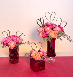 Three vibrant peach and pink bouquets of various sizes created with Miyabi and Edith garden roses, seeded eucalyptus and lily grass shaped into hearts.