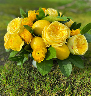 A compote design inspired by the Pantone Color of the Year 2021, "Ultimate Gray and Illumination Yellow" features bright yellow lemons, ranunculus and two kinds of garden roses: Catalina and Lemon Pom Pom.