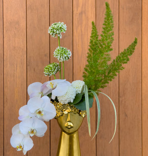 Elegant phalaenopsis orchids in a gold head.