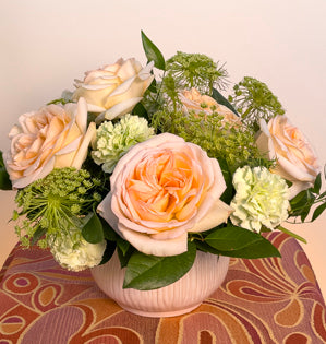 A classic round design created with Princess Maya Roses, carnations, and Queen Anne's Lace, paired with Italian and Israeli ruscus, and salal leaves.