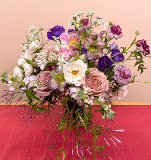 A wonderful spring bouquet made with, eucalyptus, jasmine vine, pieris, Majolika roses, Mocha roses, stock, lisianthus, tulips, orlaya, hellebore, and butterfly ranunculus.