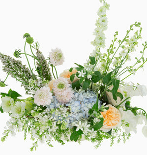 Arrangement designed with gentle whites and fresh pastels.