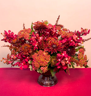 A lovely textural compote design full of israeli and Italian ruscus, foraged tobbaco, variegated pittosporum, cottage yarrow, rudbeckia, and Mokara Orchids.