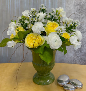 This willow armature design brings together sunny garden roses and soft white blooms in a green vase.