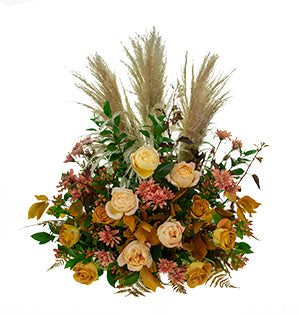 A floral design for the church altar mixes Caramel Antique roses, Heart of Gold roses, pampas, preserved fern, preserved beech, hypericum, chrysanthemums, fatsia, and Israeli ruscus.