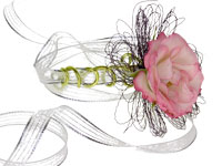 Prom flowers can be worn in the hair, as a necklace, ring, or belt, on the ankle, or on the arm like this lovely wrist corsage with a pink rose placed on a delicate bracelet and tied with sheer ribbon streamers.
