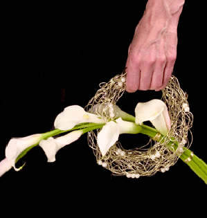 An elegant and sophisticated bridal bouquet is created from mini callas artistically placed in a gold wire wreath.
