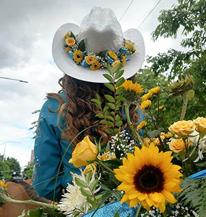 Members of an equestrian court decorate their parade horses with gorgeous floral designs on the horses' bridles, tails, and rumps. 