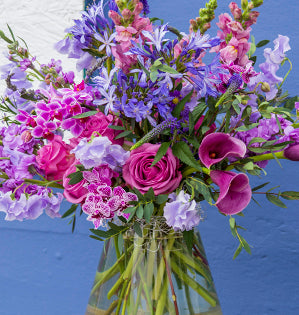 A lush and gorgeous floral design styled in the Pantone Color of the Year for 2022 Very Peri features Phalaenopsis orchids, roses, callas, stock, sweet peas, agapanthus, mini asters, veronica, lavender, snapdragons, eryngium, and gunnii eucalyptus.