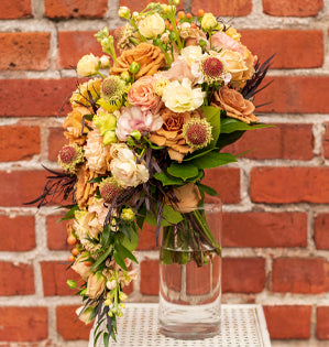 Cascading bouquet of roses against a brick background.