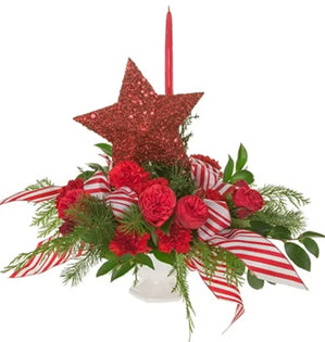 Decorative Christmas arrangement with red star, flowers, and ribbons on a white background